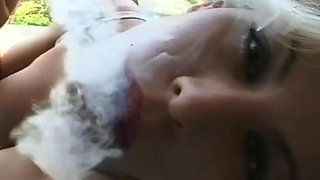 Busty chick in bra smokes cigarette