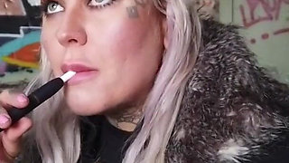 Blonde lady smokes an electronic cigarette on stair