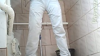 Beautiful tall brunette chick in white jeans pisses in the toilet