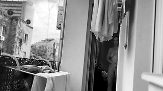 Naked chubby woman hangs out laundry on the balcony for