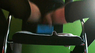 Riding 22 cm long dildo on chair in latex and heels.